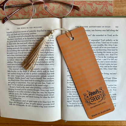 Orange gingham back of the Bumblebee Bibliophiles bookmark with logo and Made in Australia text, on an open book