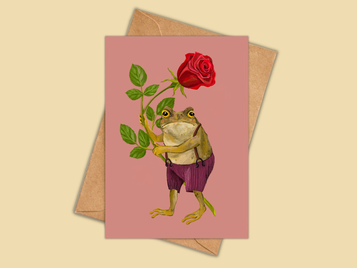 Love from Gustav greeting card by Anna Seed: a toad in purple overalls holding a big red rose, on dusty pink