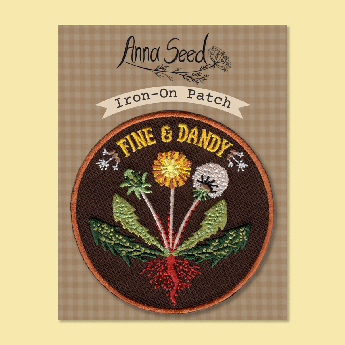 Fine & Dandy patch on its gingham Iron-On Patch backing card, yellow dandelion and seed head stitched on brown