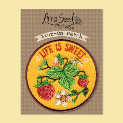 Life Is Sweet patch on its gingham Iron-On Patch backing card, red strawberries and leaves stitched on yellow