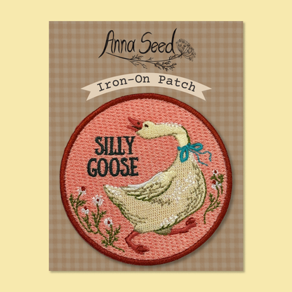 Silly Goose patch on its gingham Iron-On Patch backing card, a white goose with blue ribbon stitched on pink