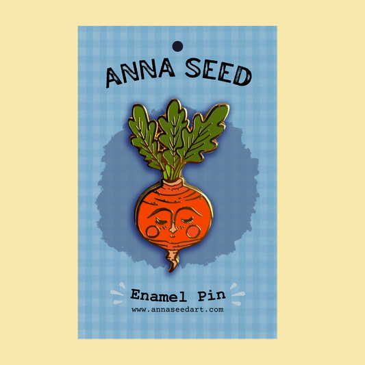 Sweet Radish enamel pin by Anna Seed, a smiling orange radish with a leafy green top on a blue gingham backing card