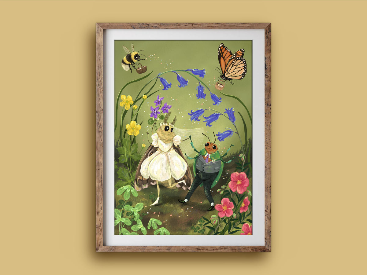 A Wee Wedding art print in a wooden frame, a moth bride and beetle groom among wildflowers, on a mustard wall