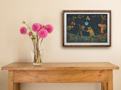 Blue Moon landscape print of a moonlit woodland dance, framed on a cream wall above a table with pink dahlias