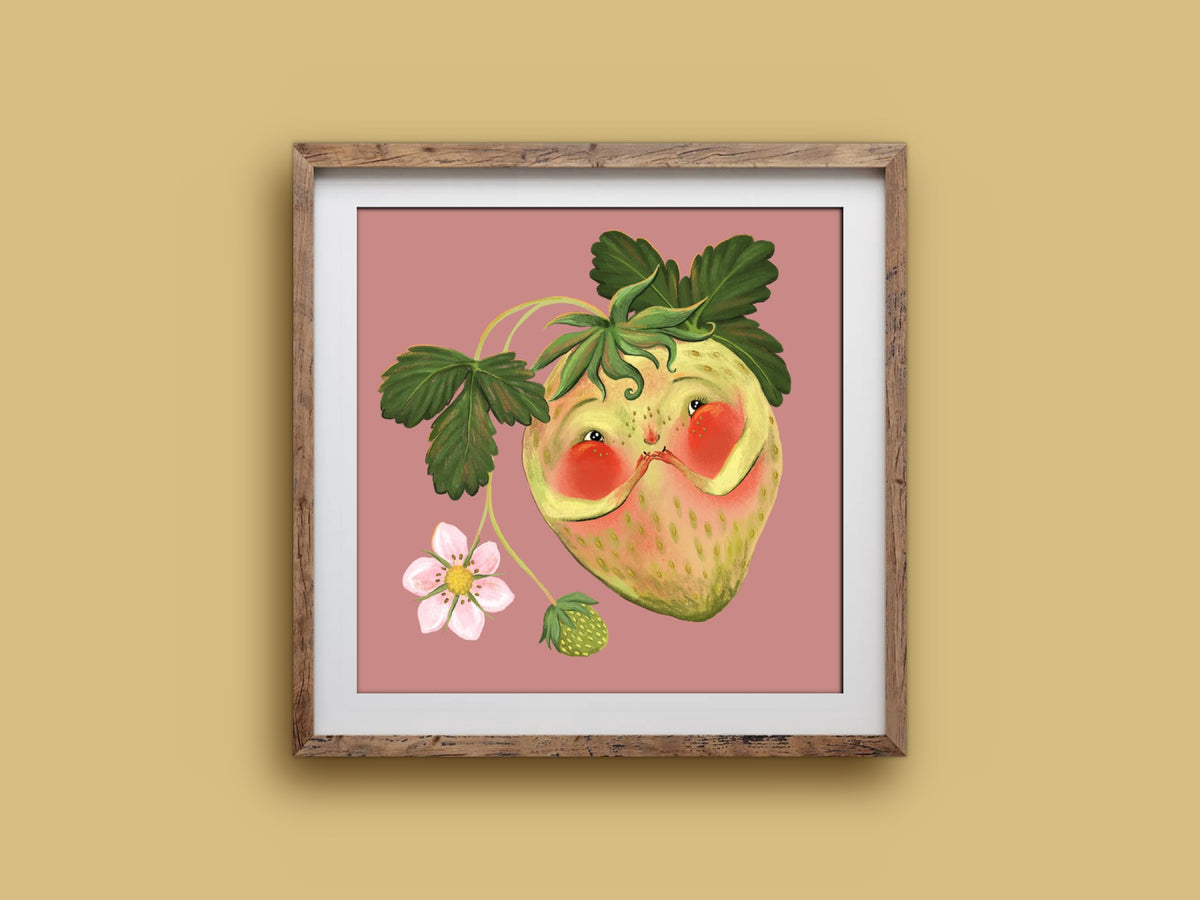 Blushing Berry art print in a wooden frame, a shy blushing strawberry with leaves and a flower, on a mustard wall
