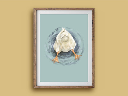 Butt Quack print in a rustic wooden frame on a mustard wall, showing a duck's fluffy bottom and orange feet poking out of the water