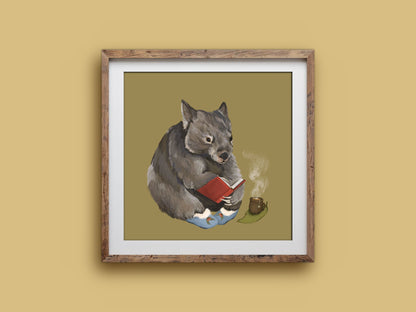 Cosy Wombat print in a rustic square wooden frame on a mustard wall, showing a wombat reading with a cuppa on a gum leaf