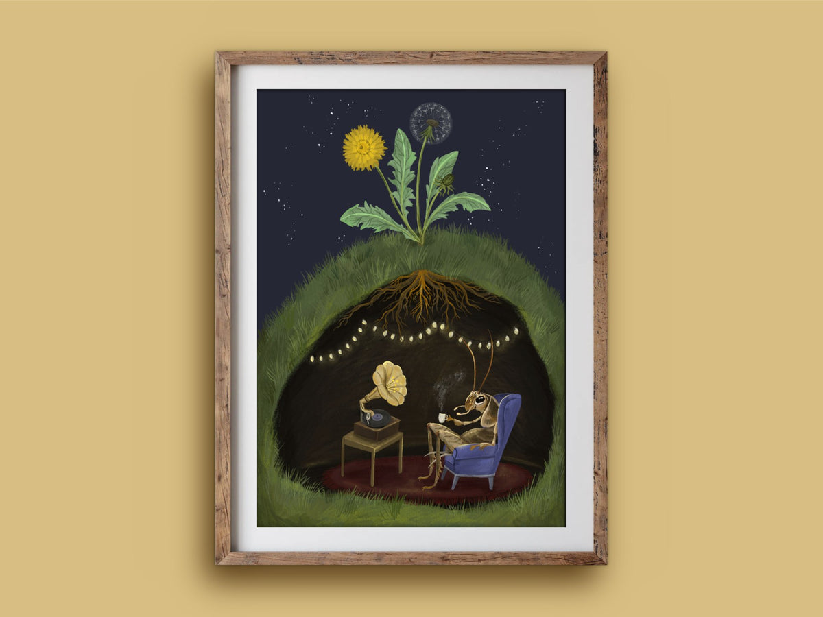 Cricket at Home print in a rustic wooden frame on a mustard wall, showing a cosy underground room lit by fairy lights at night