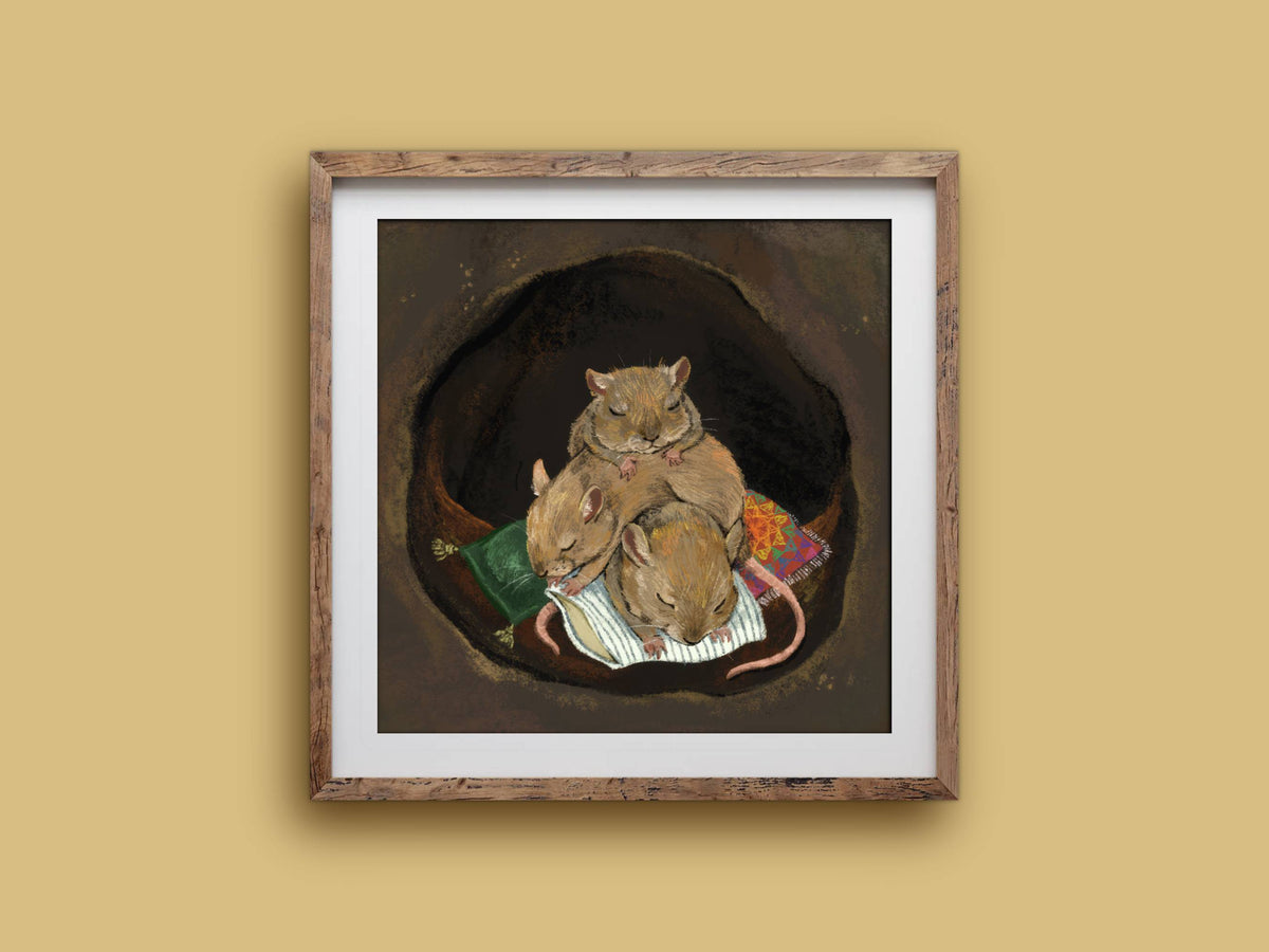 Cuddle Puddle print in a rustic square wooden frame on a mustard wall, showing three sleeping mice piled together in a burrow