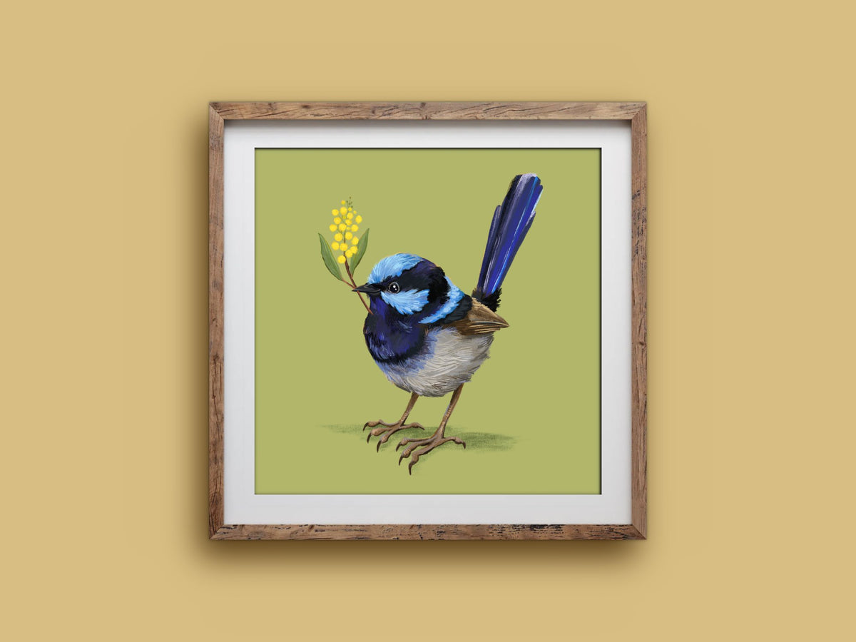 Fairy Wren print in a rustic square wooden frame on a mustard wall, showing a blue wren with a tall tail and yellow wattle