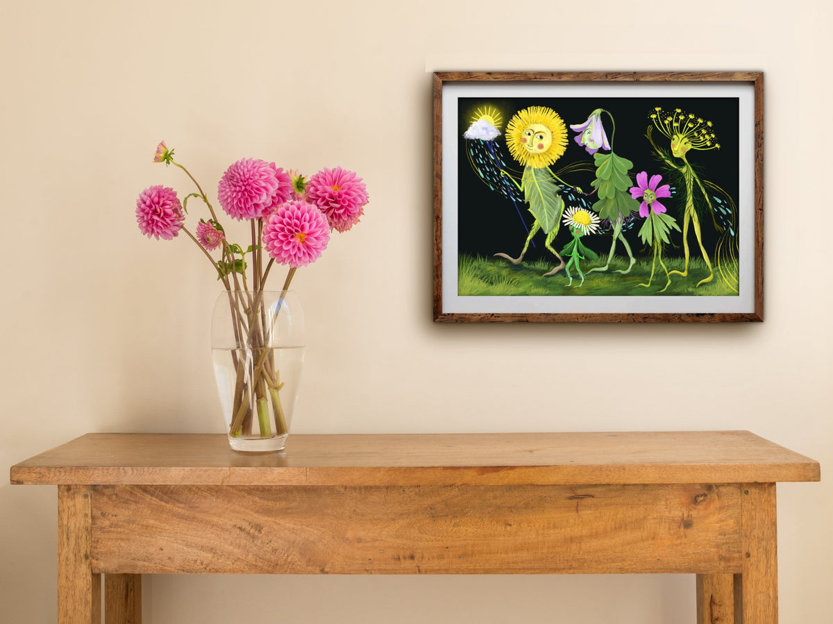 Framed Flower Parade print of spring flower characters walking in procession, hung above a wooden side table with dahlias