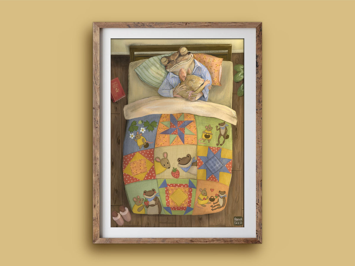 Good Morning print in a timber frame: a frog cuddling a mouse in bed beneath a quilt patterned with stars and critters
