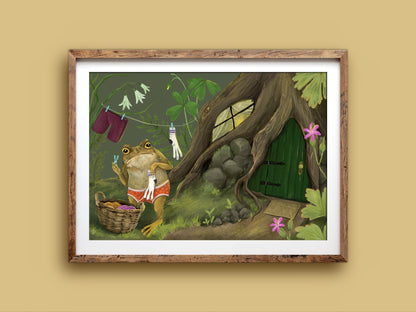 Laundry Toad landscape print in a rustic timber frame: a toad hanging socks beside a basket and a green door in a tree
