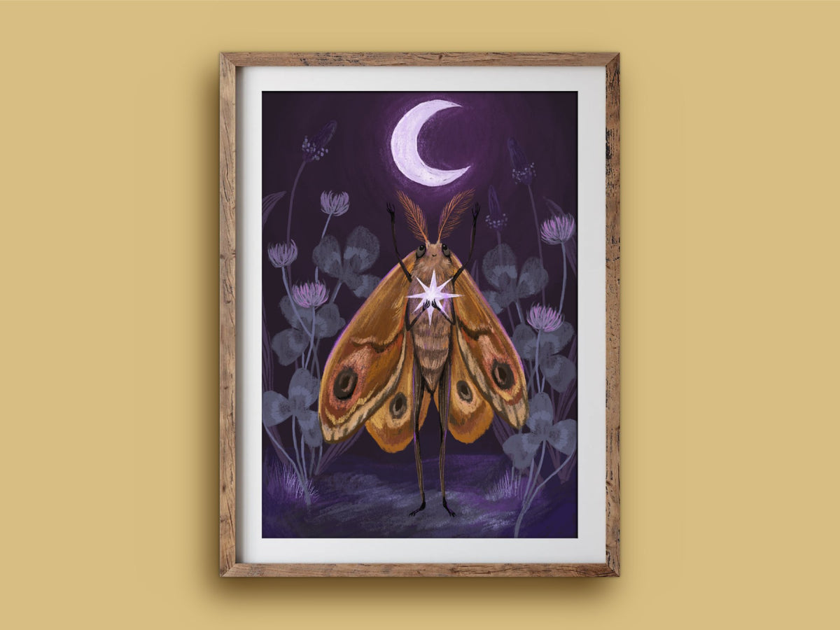 Moth's Dream print in a wooden frame on a mustard wall, an amber moth among clover flowers holding a star