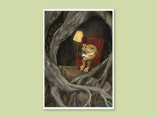 Reading Toad art print by Anna Seed: a toad reads a book in a red armchair by lamplight, nestled among gnarled tree roots
