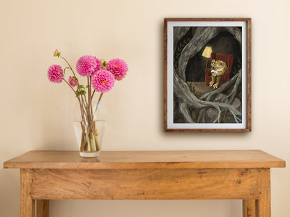 Framed Reading Toad print hung above a wooden table with pink dahlias, a toad reading in a red wingback chair