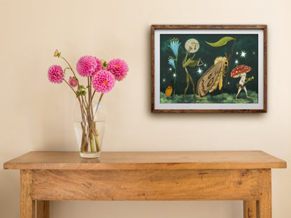 Framed Starlight Parade landscape print hung above a wooden table with pink dahlias, showing the night-time parade