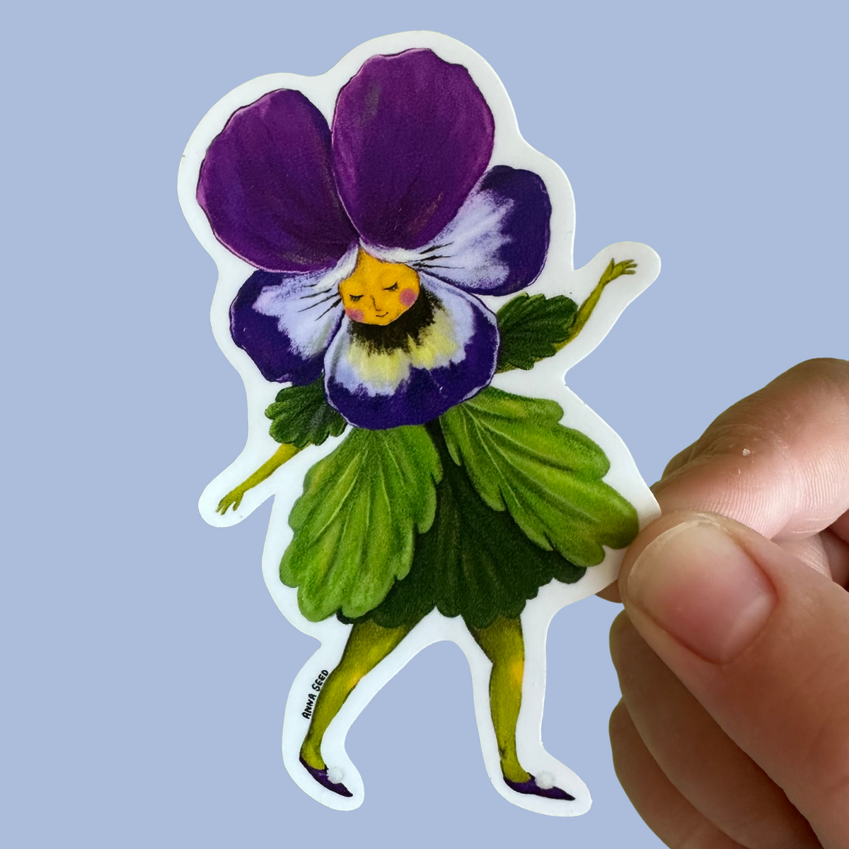 Pansy Lady sticker by Anna Seed: a dancing girl with a purple pansy flower head and a green leaf skirt, held on blue