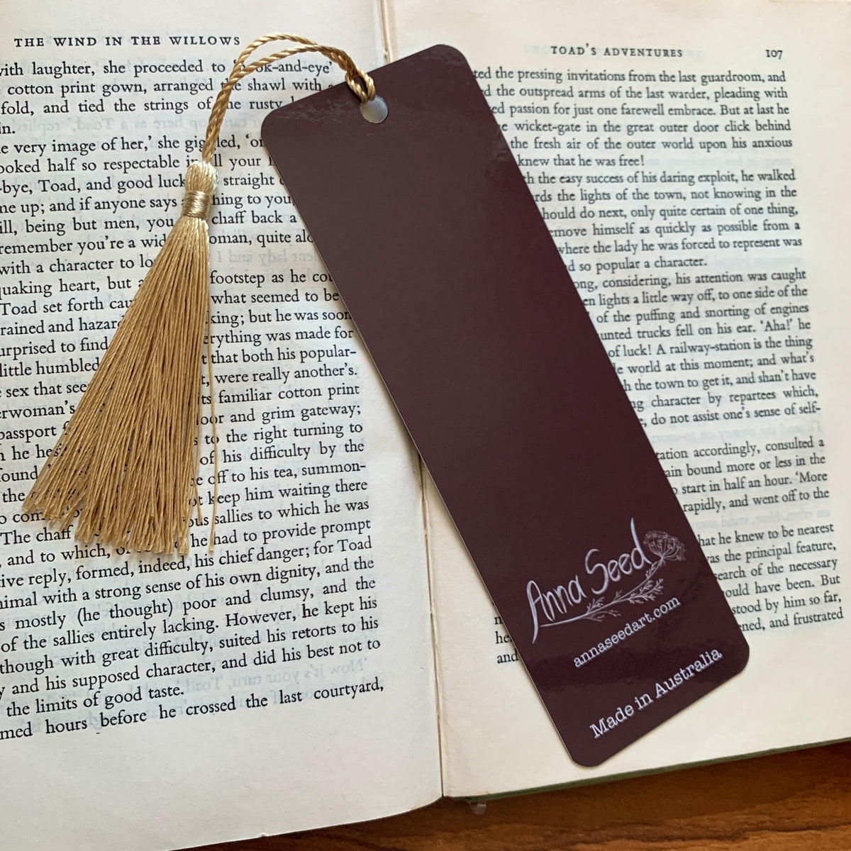 Plum back of the Reading Toad bookmark with logo, website and Made in Australia text, on an open book