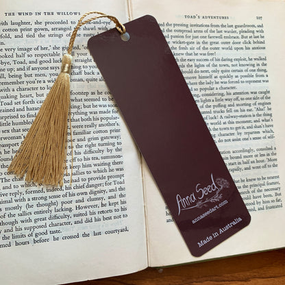 Plum back of the Reading Toad bookmark with logo, website and Made in Australia text, on an open book